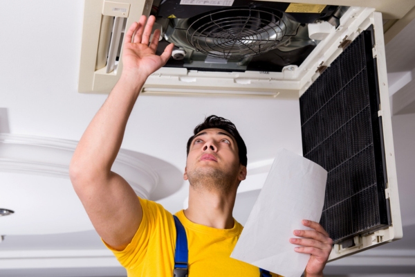 HVAC technician dealing with broken centralized air conditioner