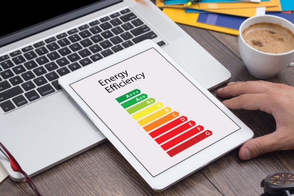 homeowner looking at energy efficiency meter on smart tablet depicting energy-efficient air conditioner