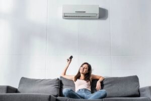 woman on the couch enjoying the cool breeze from a new air conditioner